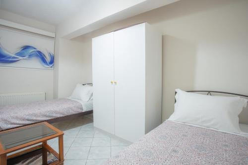 a bedroom with two beds and a mirror at GIANΝS HOME in Marantochori
