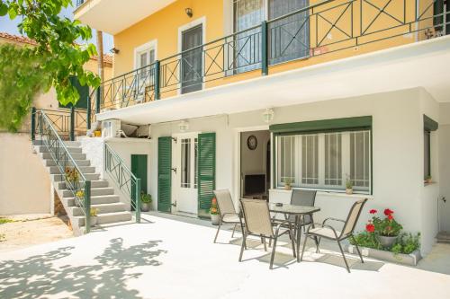 a patio with a table and chairs in front of a house at GIANΝS HOME in Marantochori