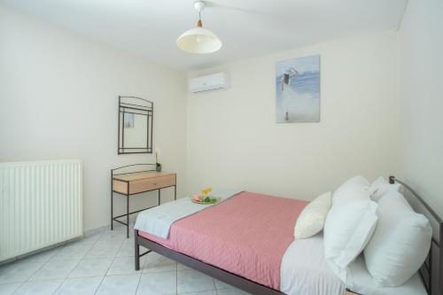 1 dormitorio con 1 cama con manta rosa y blanca en GIANΝS HOME, en Marantochori