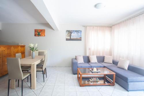 a living room with a blue couch and a table at GIANΝS HOME in Marantochori
