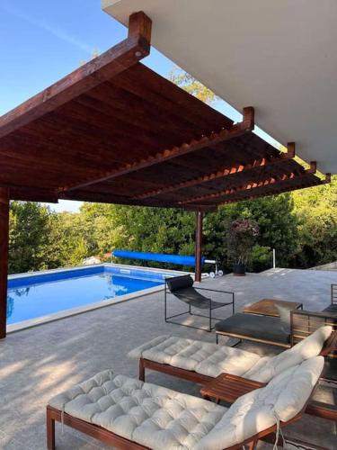 a pavilion with chairs and a pool in a backyard at Villa Hedonic in Ulcinj