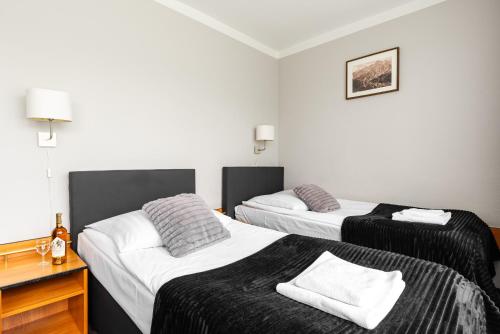 two beds in a hotel room with two at Hotel Helios 300m od Krupówek nowy BASEN od 12 lipca in Zakopane