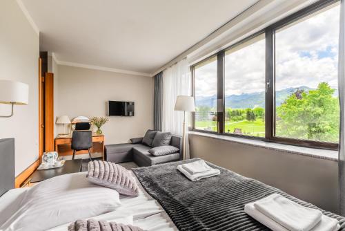 ein Schlafzimmer mit einem Bett und einem großen Fenster in der Unterkunft Hotel Helios in Zakopane