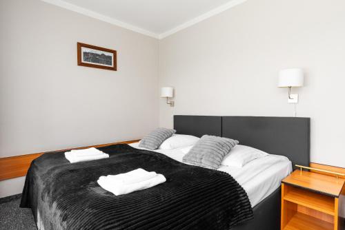 a bedroom with a large bed with two towels on it at Hotel Helios 300m od Krupówek nowy BASEN od 12 lipca in Zakopane