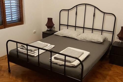 a bed with a metal frame with towels on it at Villa Hedonic in Ulcinj