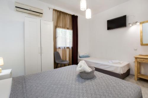 a room with two beds and a table and a tv at Marti Garden Suites in Skala Prinou