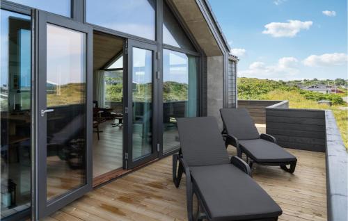 a balcony with two chairs and glass windows at 3 Bedroom Lovely Home In Hjørring in Hjørring