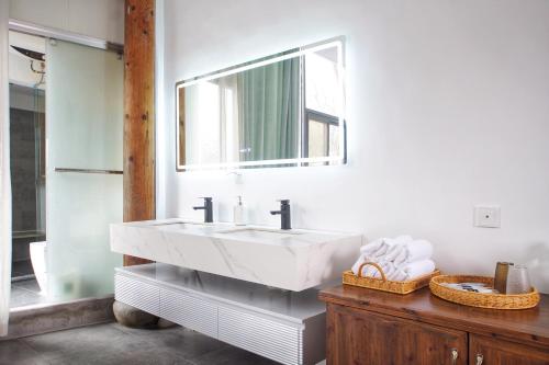 a bathroom with a white sink and a mirror at Alina Garden Boutique Resort Huangshan Hongcun in Huangshan Scenic Area