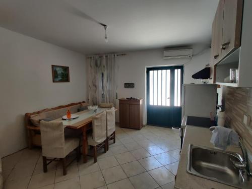 a kitchen and dining room with a table and a refrigerator at CORFU FOTIS house in Neochorákion