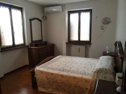 a bedroom with a bed and a mirror and windows at Villetta Indipendente in San Zeno di Montagna