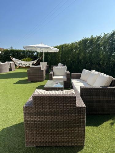 a group of wicker chairs and tables on a lawn at B&B Villa Fabrizia in Diamante