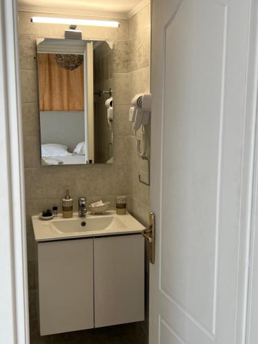 bagno con lavandino bianco e specchio di Anoixi Apartments a Korissía