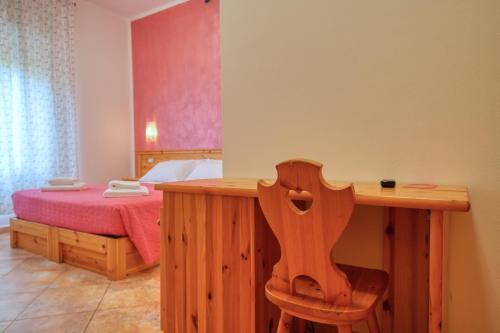 a bedroom with a bed with a wooden table and a desk at Camere da Mirella in Lazise