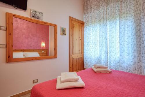 a bedroom with a red bed with a mirror at Camere da Mirella in Lazise