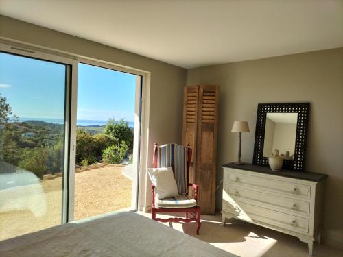 une chambre avec un lit, une commode et un miroir dans l'établissement Lou Roucaou, à La Croix-Valmer