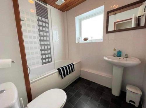a bathroom with a toilet and a sink and a bath tub at Villa sea view 3-bed heated pool eat bar kids park in Lowestoft