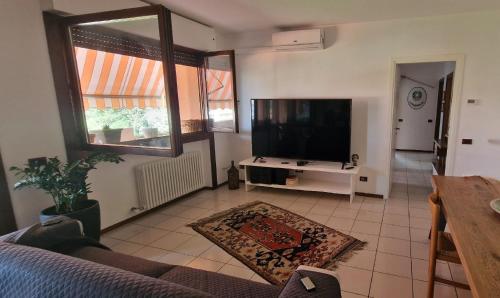 uma sala de estar com um sofá e uma televisão de ecrã plano em Alicia em Bérgamo
