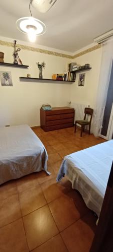 a bedroom with two beds and a chair in it at Casa Fiorella in Stiava