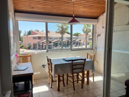 une salle à manger avec une table et des chaises et une fenêtre dans l'établissement Appartement 6 couchages La Londe-les-Maures 8, à La Londe-les-Maures