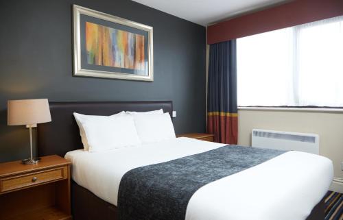 um quarto de hotel com uma cama e uma janela em The Broughton Hotel by Greene King Inns em Milton Keynes