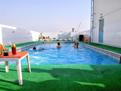 a group of people swimming in a swimming pool at Signature Inn Hotel in Dubai