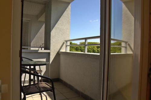 balkon ze stołem i krzesłami oraz oknem w obiekcie Apartamenty Kolorowe Etna w Kołobrzegu