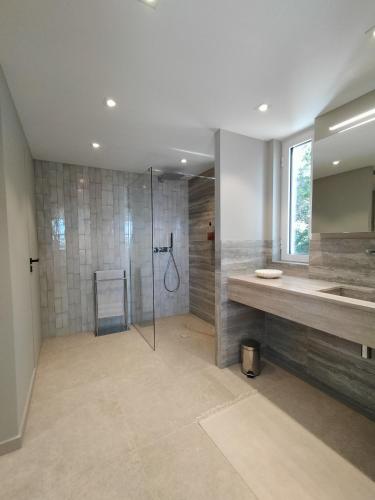une grande salle de bain avec douche et lavabo dans l'établissement Lou Roucaou, à La Croix-Valmer