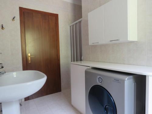 ein Badezimmer mit einer Waschmaschine und einem Waschbecken in der Unterkunft Appartamento Panorama Lago di Ledro in Mezzolago