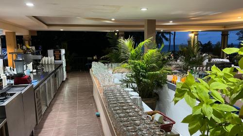 a restaurant with a bar with glasses on a counter at Kata Villa Merit Hill Bungalows in Ban Karon
