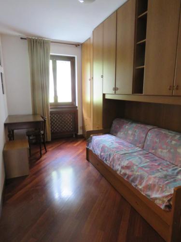 Zimmer mit einem Bett und einem Schreibtisch. in der Unterkunft Appartamento Panorama Lago di Ledro in Mezzolago