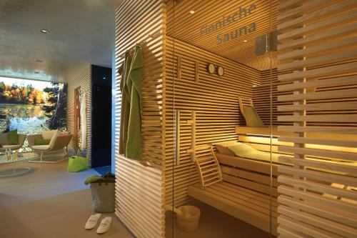 ein Schlafzimmer mit einem Bett in einer Holzwand in der Unterkunft Landidyll Hotel Restaurant Birkenhof in Klosterkumbd