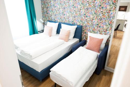two beds in a room with a floral wallpaper at House of Blooms in Fulda