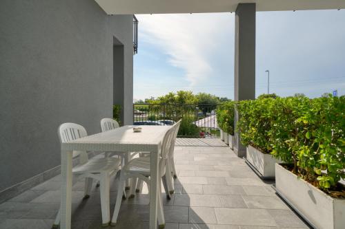 a white table and chairs on a balcony at Camere da Mirella in Lazise