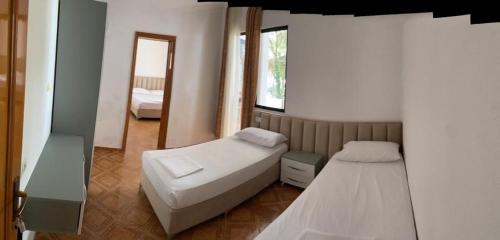 um pequeno quarto com 2 camas e um espelho em Hotel Ani em Golem