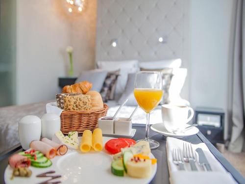 una mesa con una cesta de comida y un vaso de zumo de naranja en Soleil Boutique H, en Sopot
