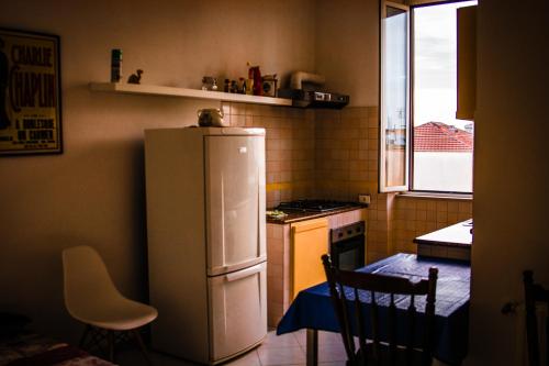 Charlie Apartment في روما: مطبخ صغير مع ثلاجة بيضاء وطاولة
