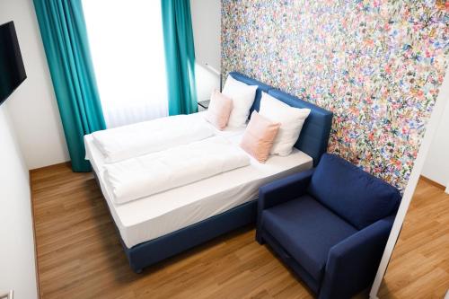 a bedroom with a bed and a blue chair at House of Blooms in Fulda