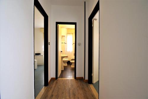 pasillo con 2 puertas que conducen a un baño en LAURA confortevole e rilassante appartamento climatizzato a due passi dalla spiaggia en Lido di Scacchi
