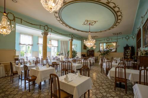 un comedor con mesas, sillas y un espejo grande en Hotel de Camprodón en Camprodon