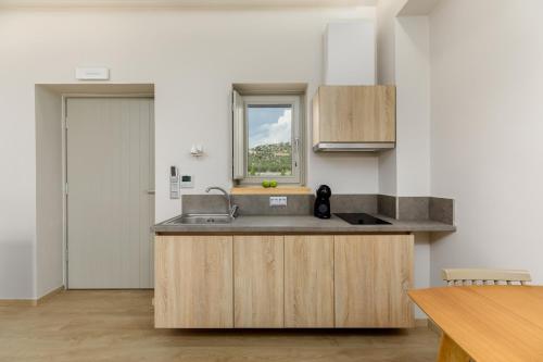uma cozinha com um lavatório e uma janela em Margazi Areopolis Luxury Rooms em Areopoli