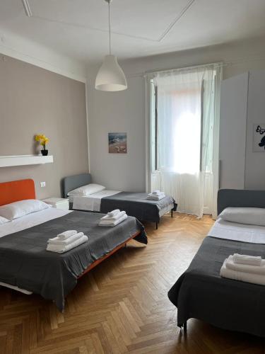 um quarto com três camas e uma janela em HAVIP em Milão