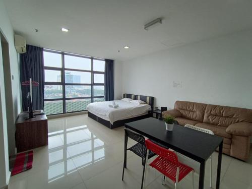- un salon avec un lit, une table et un canapé dans l'établissement WeSanitise PJ5 Soho Studio Room, à Petaling Jaya