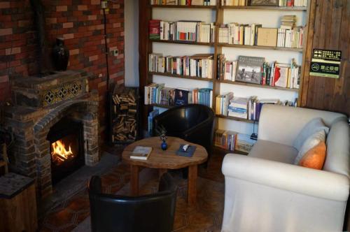 a living room with a fireplace and a couch and a table at Alina Garden Boutique Resort Huangshan Hongcun in Huangshan Scenic Area