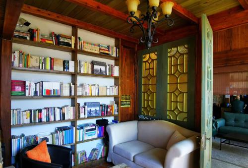 a living room with a couch and bookshelves filled with books at Alina Garden Boutique Resort Huangshan Hongcun in Huangshan Scenic Area