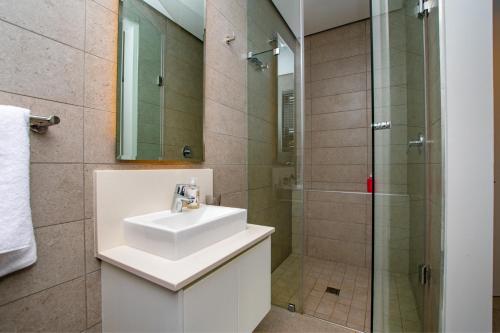 a bathroom with a sink and a shower at Oceans Edge 5, Zimbali Estate in Ballito