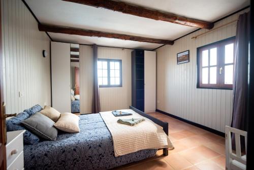 a bedroom with a bed and two windows at Casa Abubilla in Tinajo