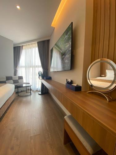 a hotel room with a bed and a mirror at Apec Mandala Chambay Mũi Né in Phan Thiet