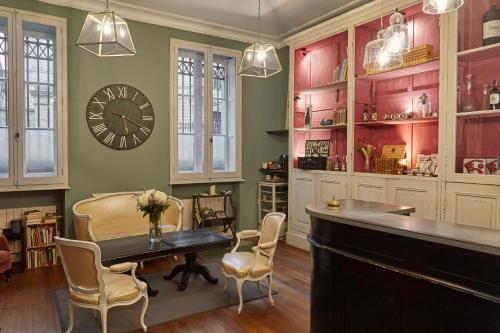 波爾多的住宿－L'Apparthôtel Particulier Bordeaux，配有桌椅和时钟的房间
