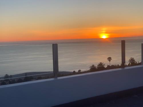 una puesta de sol sobre el océano con el sol en el cielo en Casa Merce, en Arecida