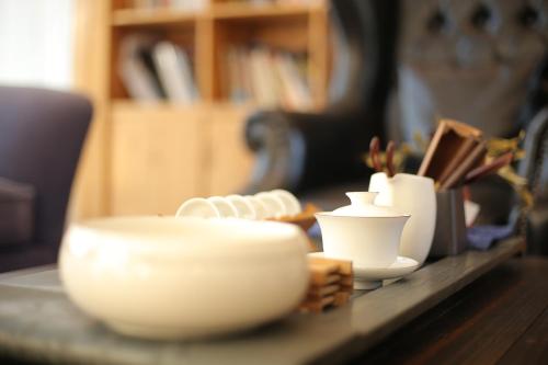 a table with white plates and cups on it at Alina Garden Boutique Resort Huangshan Hongcun in Huangshan Scenic Area